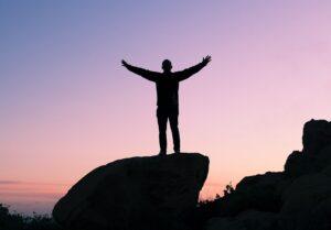 Silhouette of someone standing with arms open wide